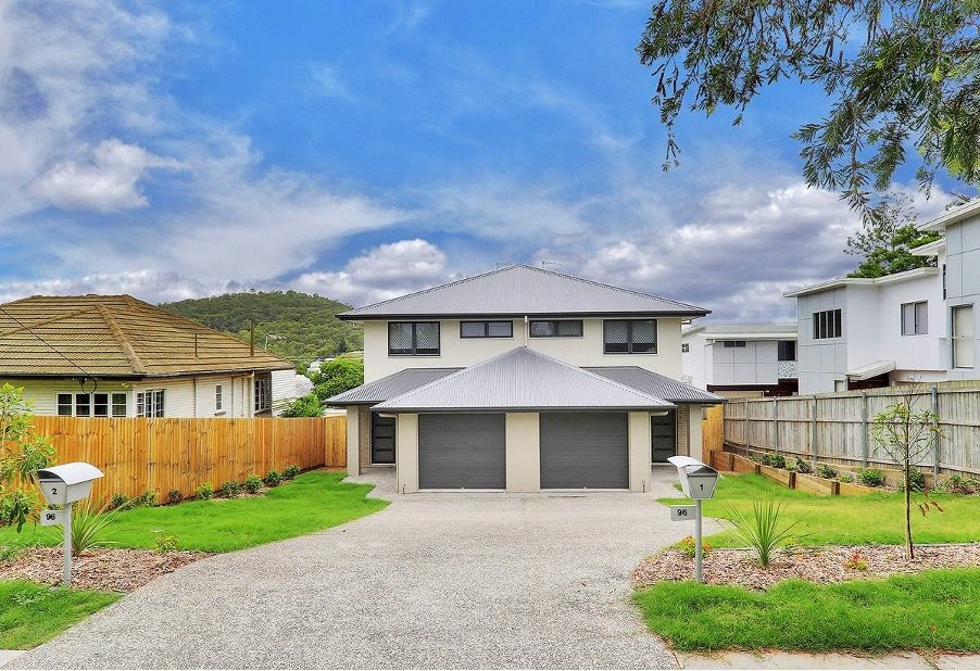 A completed Australian duplex with two garages and two separate mailboxes numbered 2 slash 96 and 96, showing two separate titles on one block.